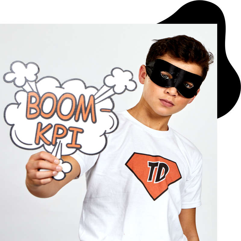 Jugendlicher mit "BOOM KPI" Schild in der Hand und Superheldenmaske vor den Augen